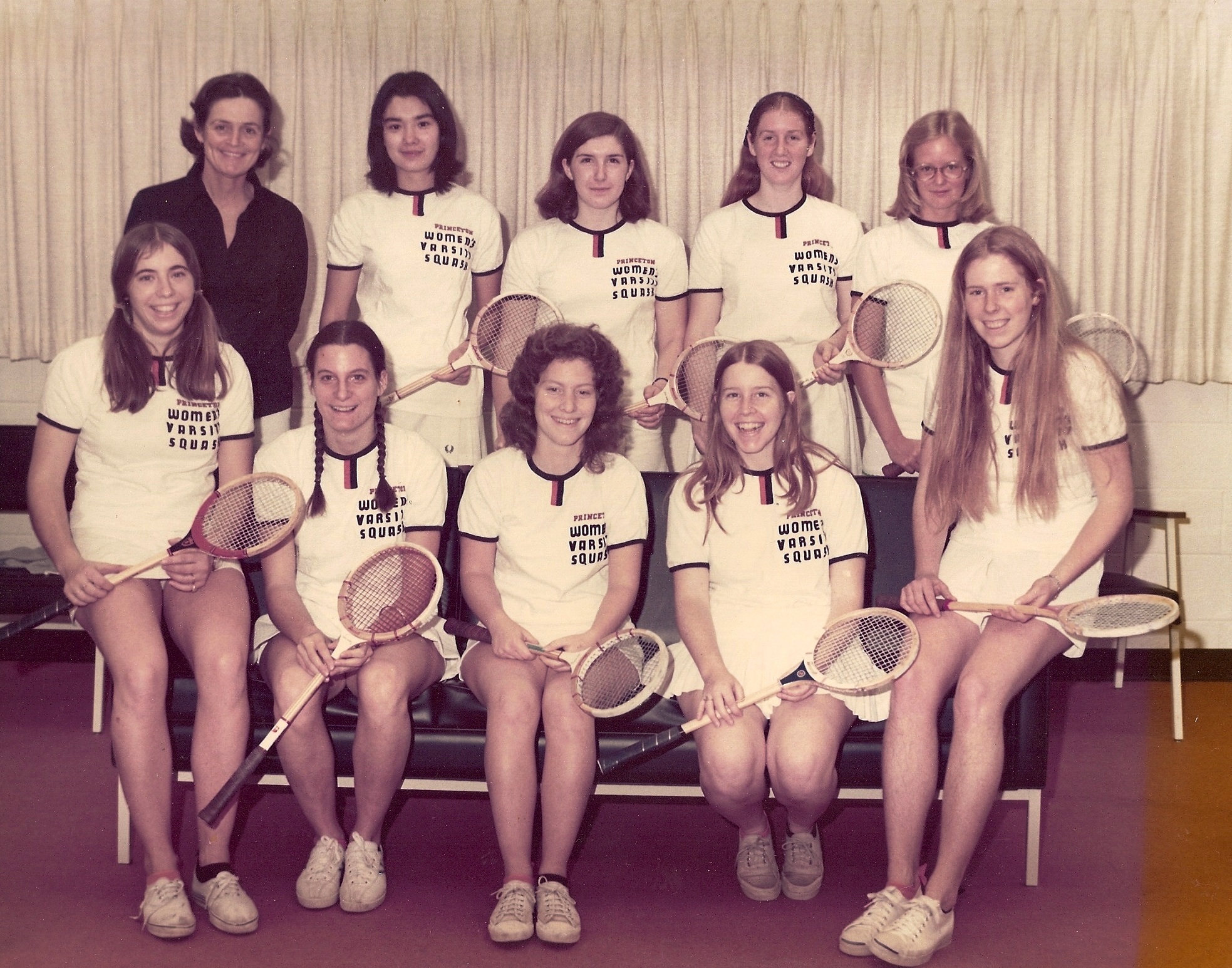 The brainchild of Betty Howe Constable and Pennsylvania coach Ann Wetzel, the intercollegiate Howe Cup (a trophy donated by Constable’s mother, Margaret Howe) began in 1973. Princeton won the Cup in 1973, the first of four straight. That 1973 team is pictured above (L-R, Top): Coach Constable, Kathy Hirata (‘75), Chris Kent (‘75), Tammy Foote, Claire Townsend (‘74); Front: CeCe Turner (‘75), Emily Goodfellow (‘76), Sally Fields (‘73, Captain), Nancy Carver (‘76), and Marion Freeman (‘74).