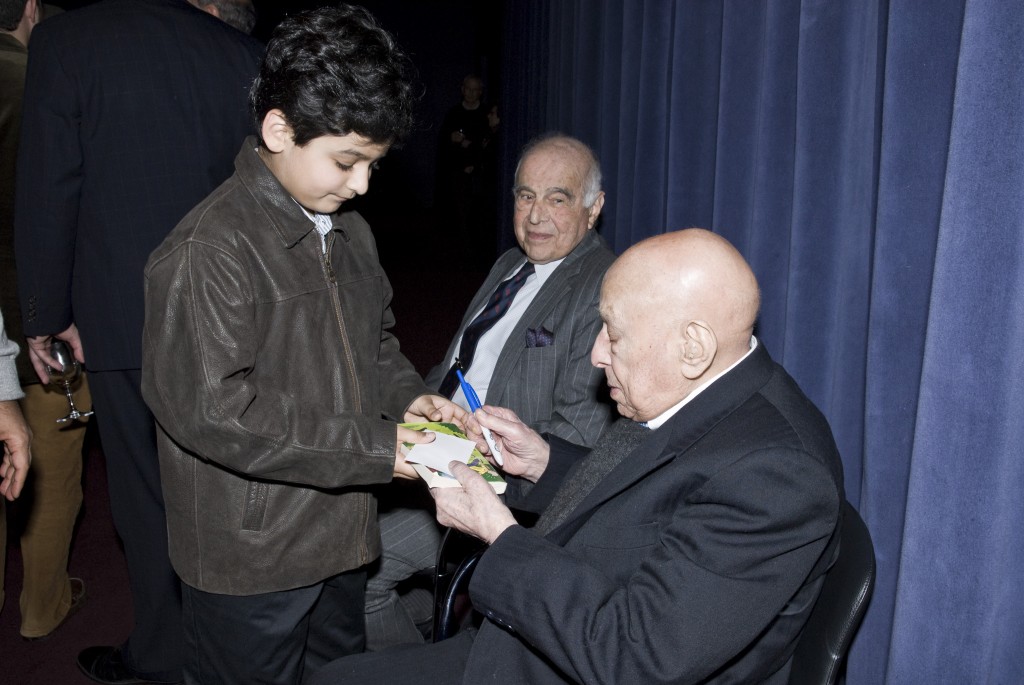 Hashim Khan signed his autograph for a young fan with former US Champion, 90-year-old Victor Elmaleh, looking on in the background.