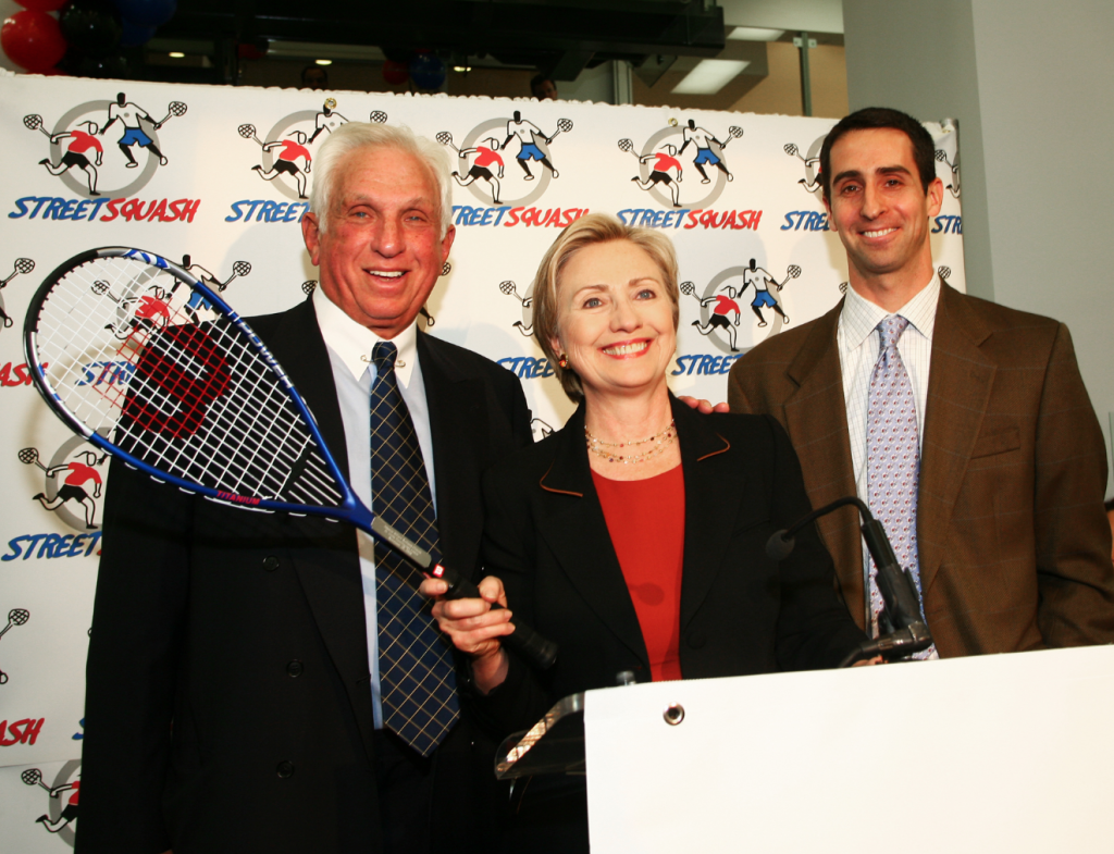 After addressing the crowd at the S.L. Green StreetSquash Center grand opening, Hillary Clinton takes a few pointers from Mr. Green and StreetSquash Executive Director, George Polsky (R).