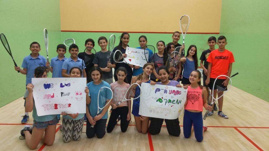 Some of the SquashBond students gathered on court in October 2015 during a particularly tense time in the country. They were holding signs that say, in Arabic, English and Hebrew: "We Live and Play Together." 